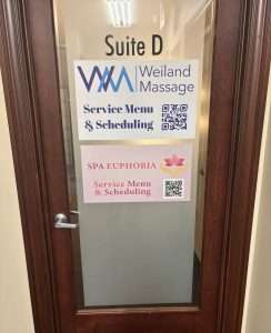 Glass entrance door with Suite D sign and service menu QR codes for Spa Euphoria in Gahanna, Ohio